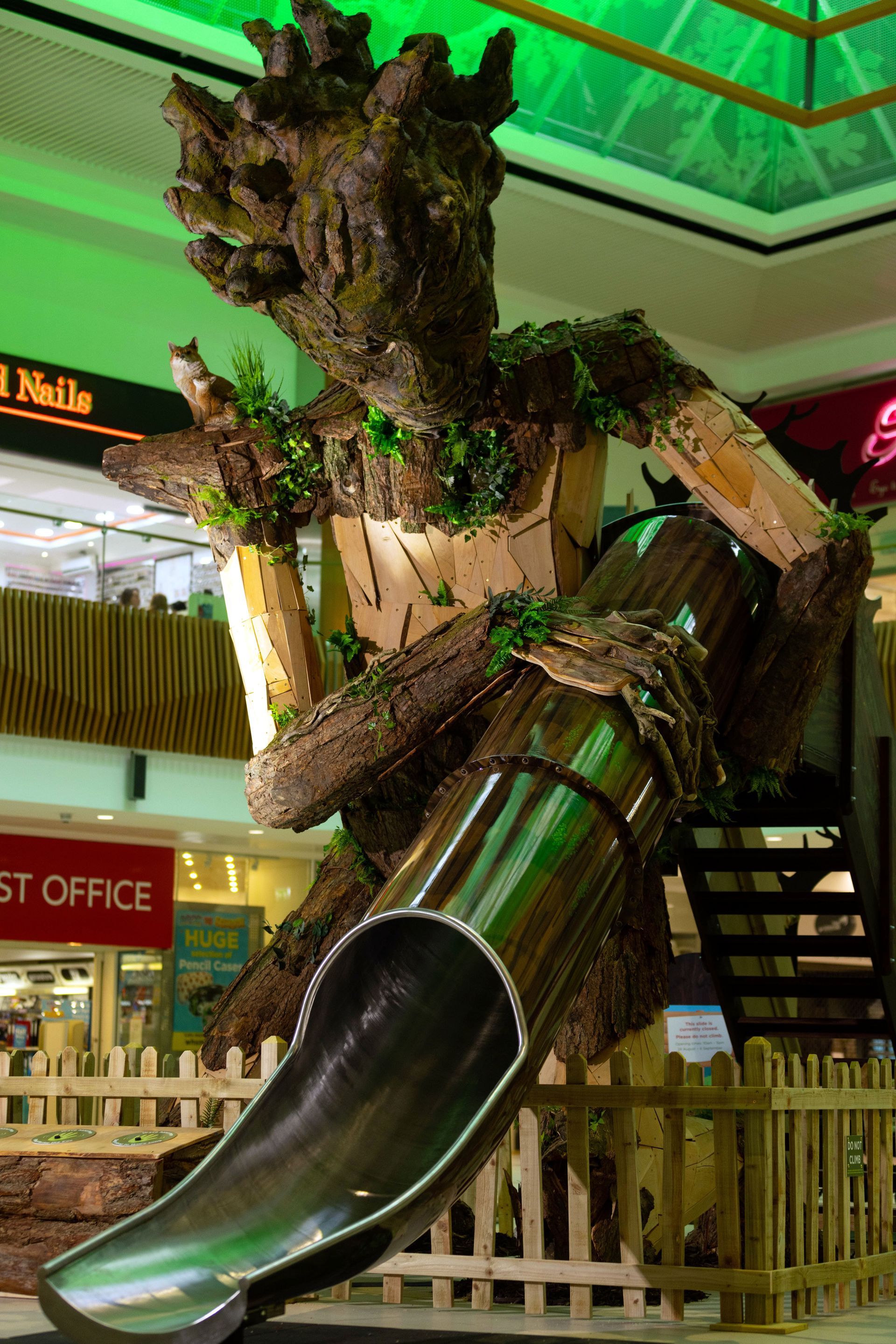 A statue of a tree with a slide in front of it