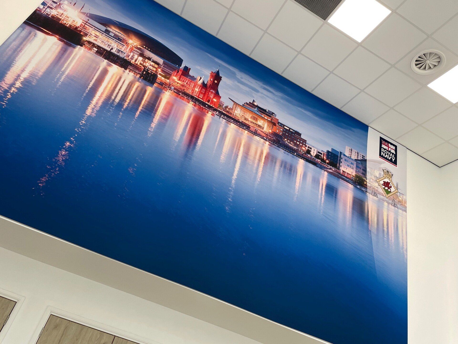 A large picture of a city is hanging on a wall.
