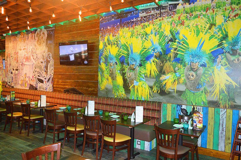 A restaurant with tables and chairs and a mural on the wall.
