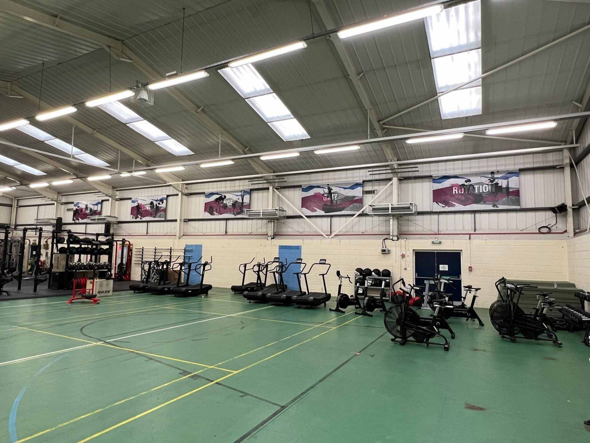 A large gym filled with lots of exercise equipment.