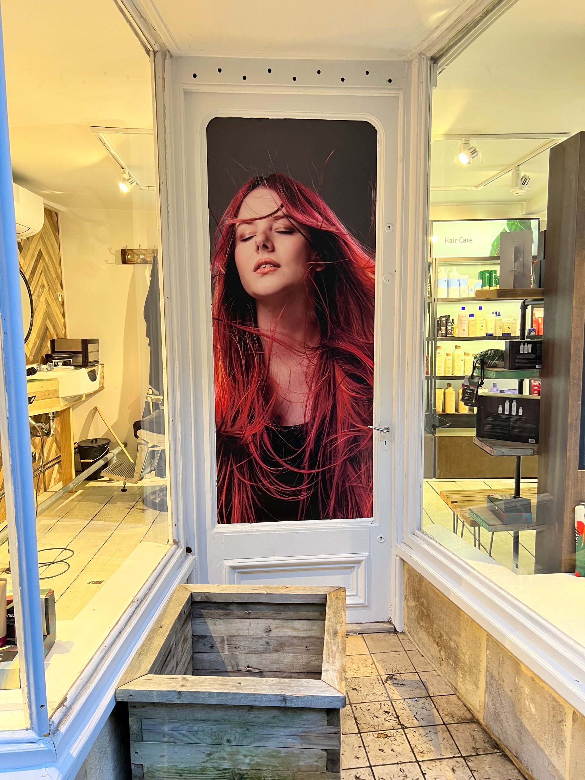 A picture of a woman with red hair is on the door of a hair salon.