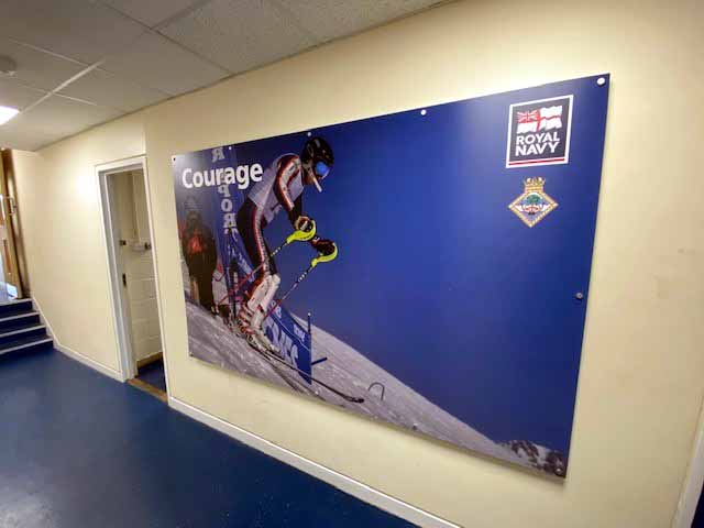 A large picture of a person skiing on a wall with the words `` courage '' written on it.
