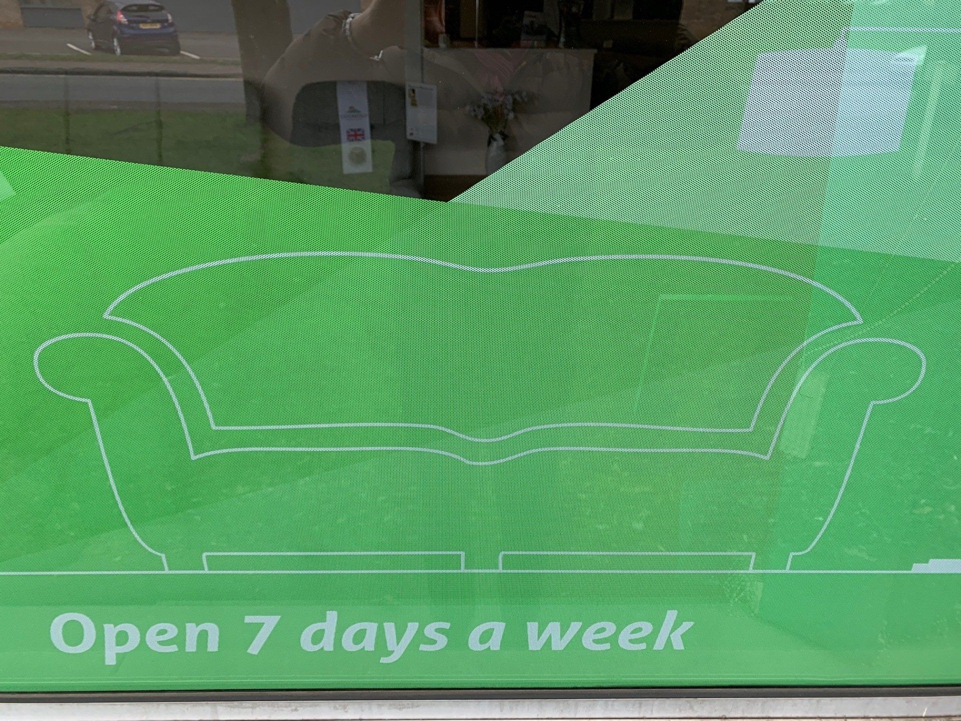 A green sign that says open 7 days a week