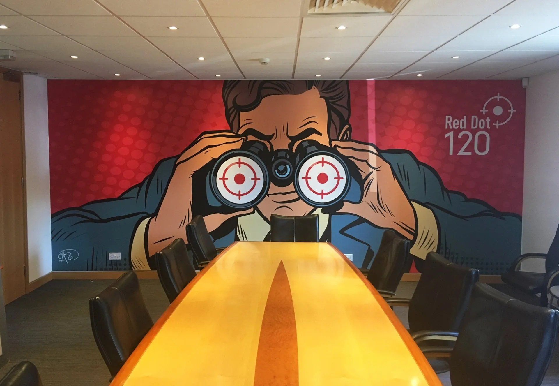 A conference room with a mural of a man looking through binoculars