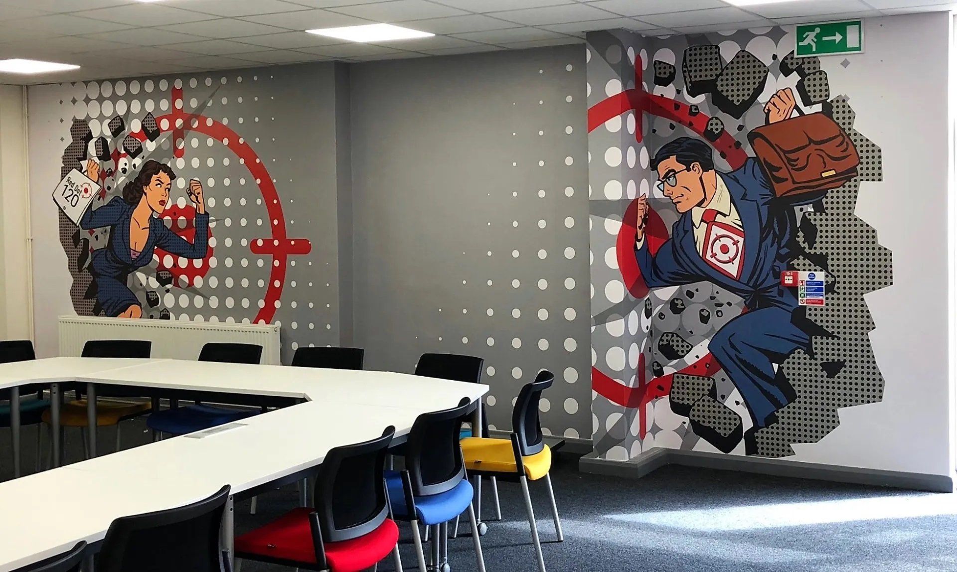 A room with tables and chairs and a mural on the wall