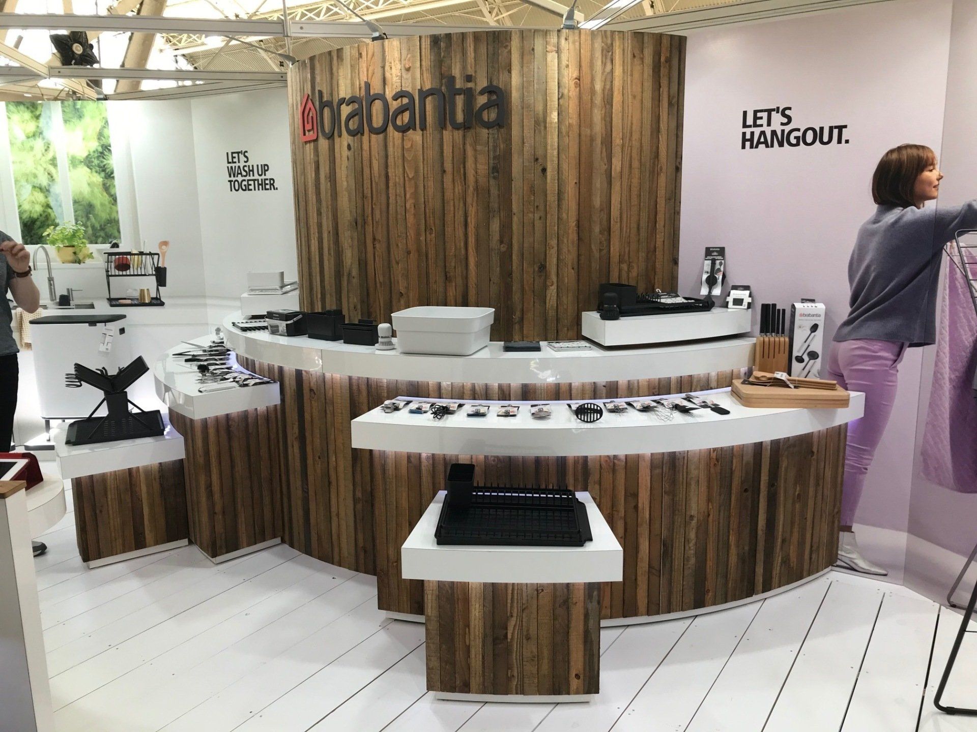 A woman is standing in front of a wooden counter in a store.