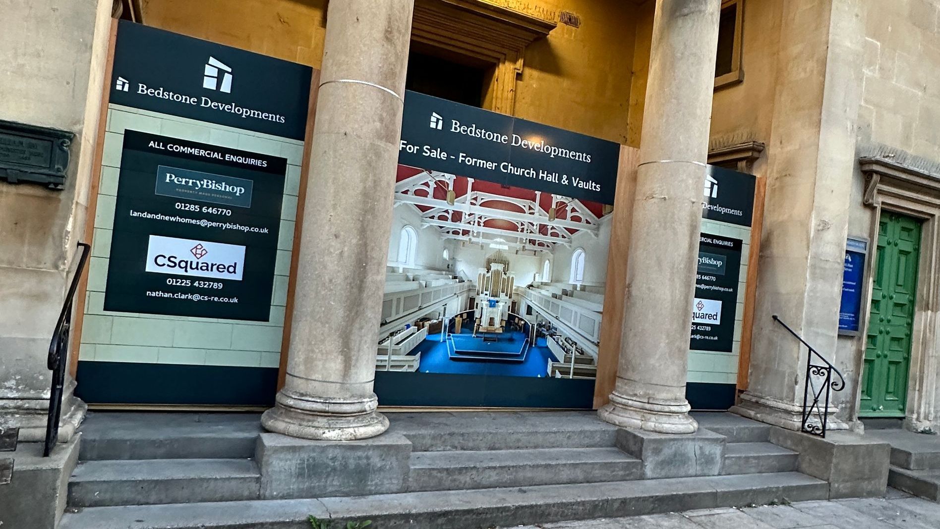 A building with a lot of signs on it and a green door.