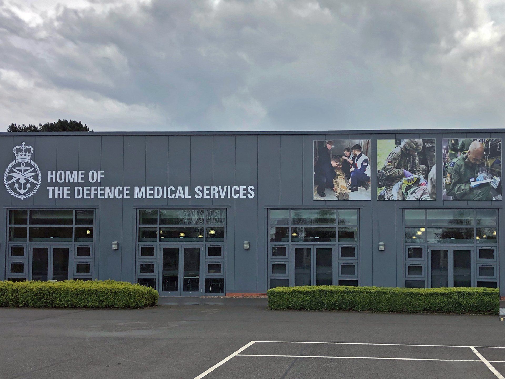 A large building with a sign that says home of the defence medical services