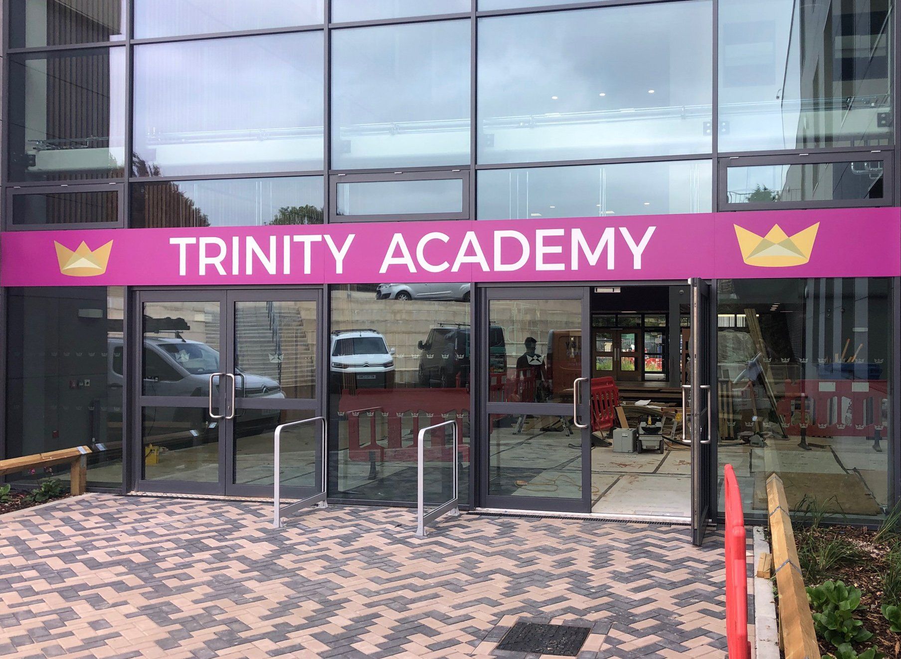 A building with a sign that says trinity academy on it