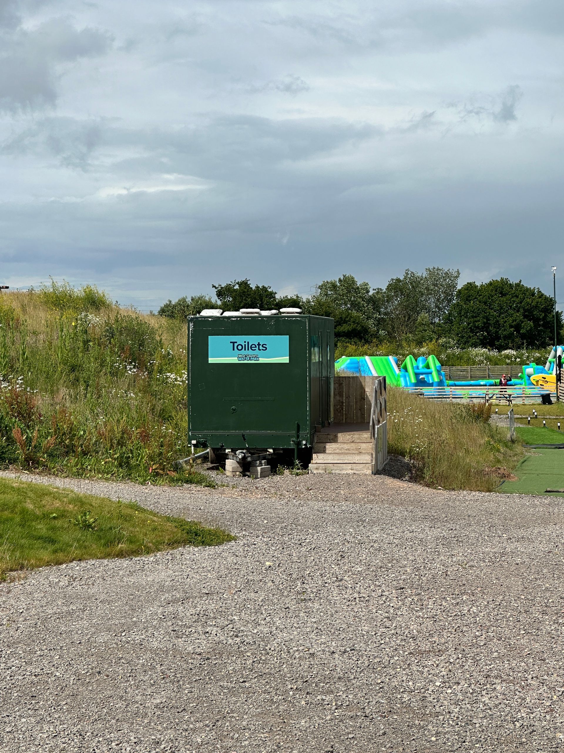 N3 Display Graphics | A green trailer is parked in a gravel lot next to a water slide.
