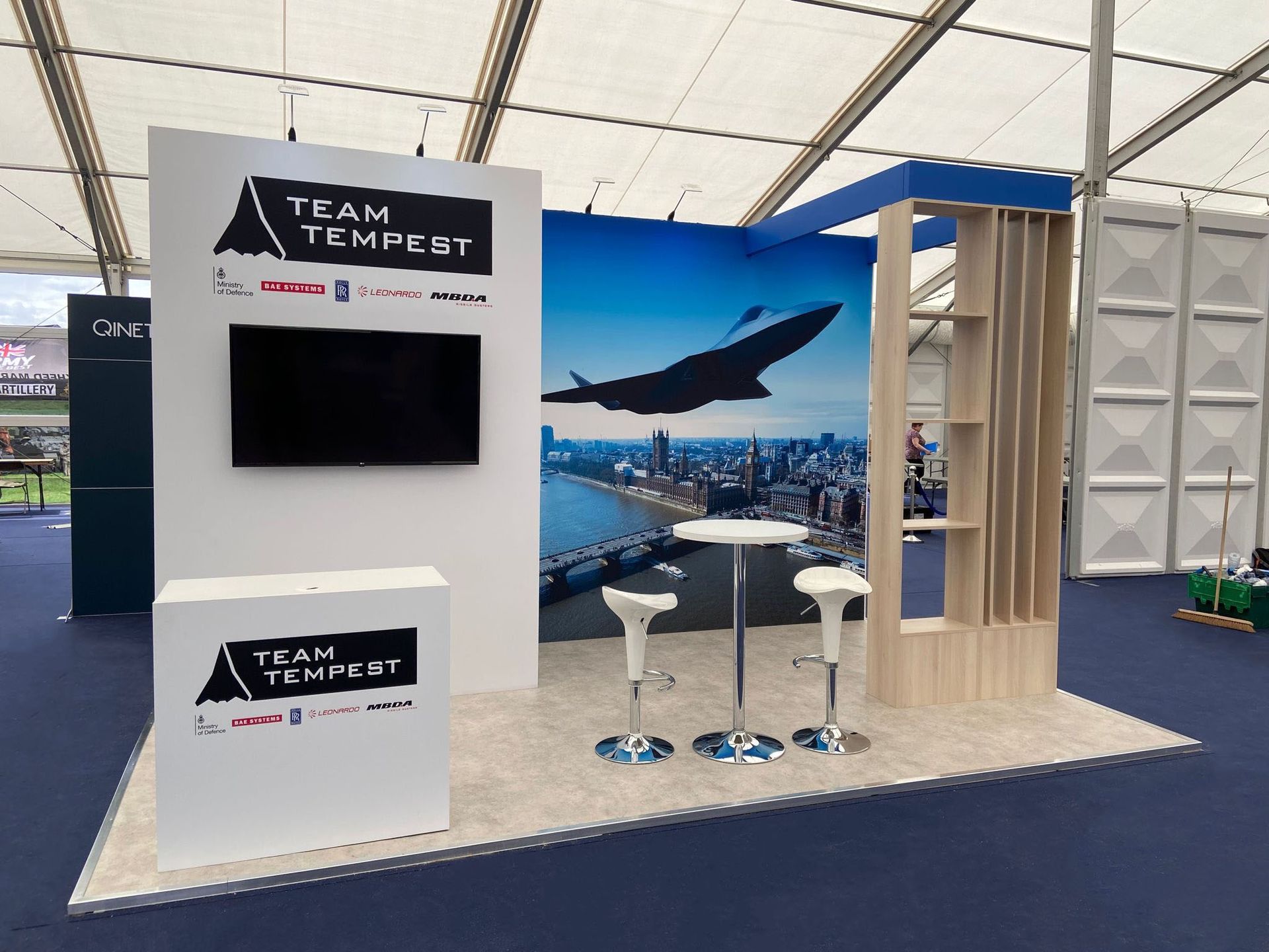 A team tempest booth with tables and chairs in a tent