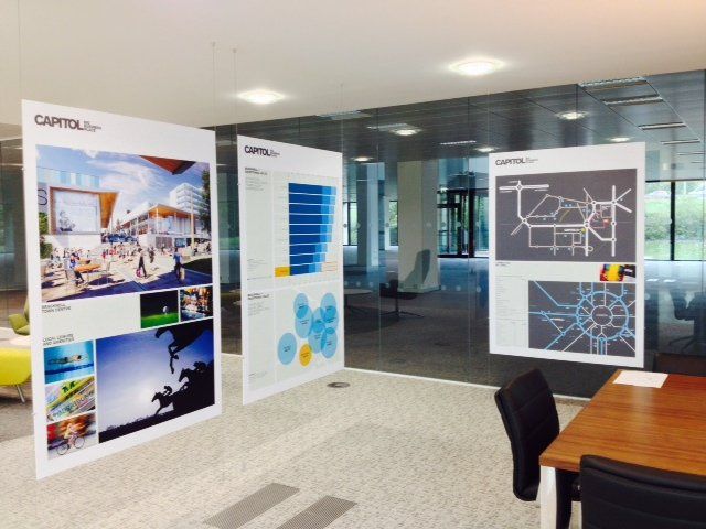 A room with a table and chairs and a sign that says capitol on it