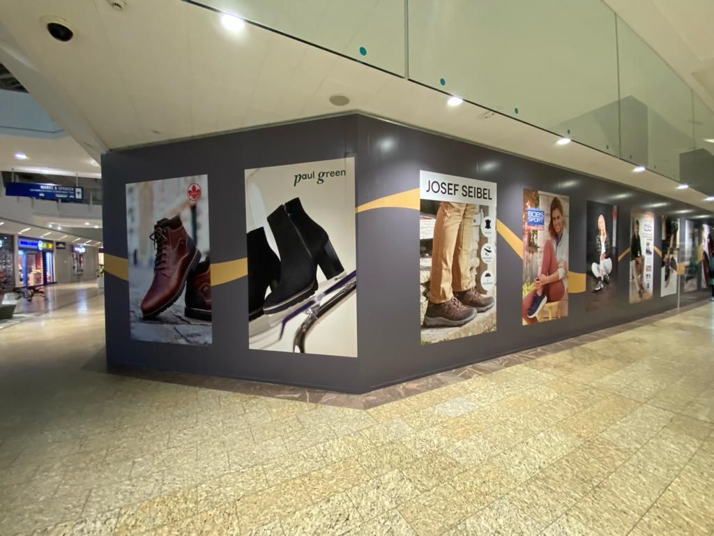 A wall with a lot of pictures of shoes on it