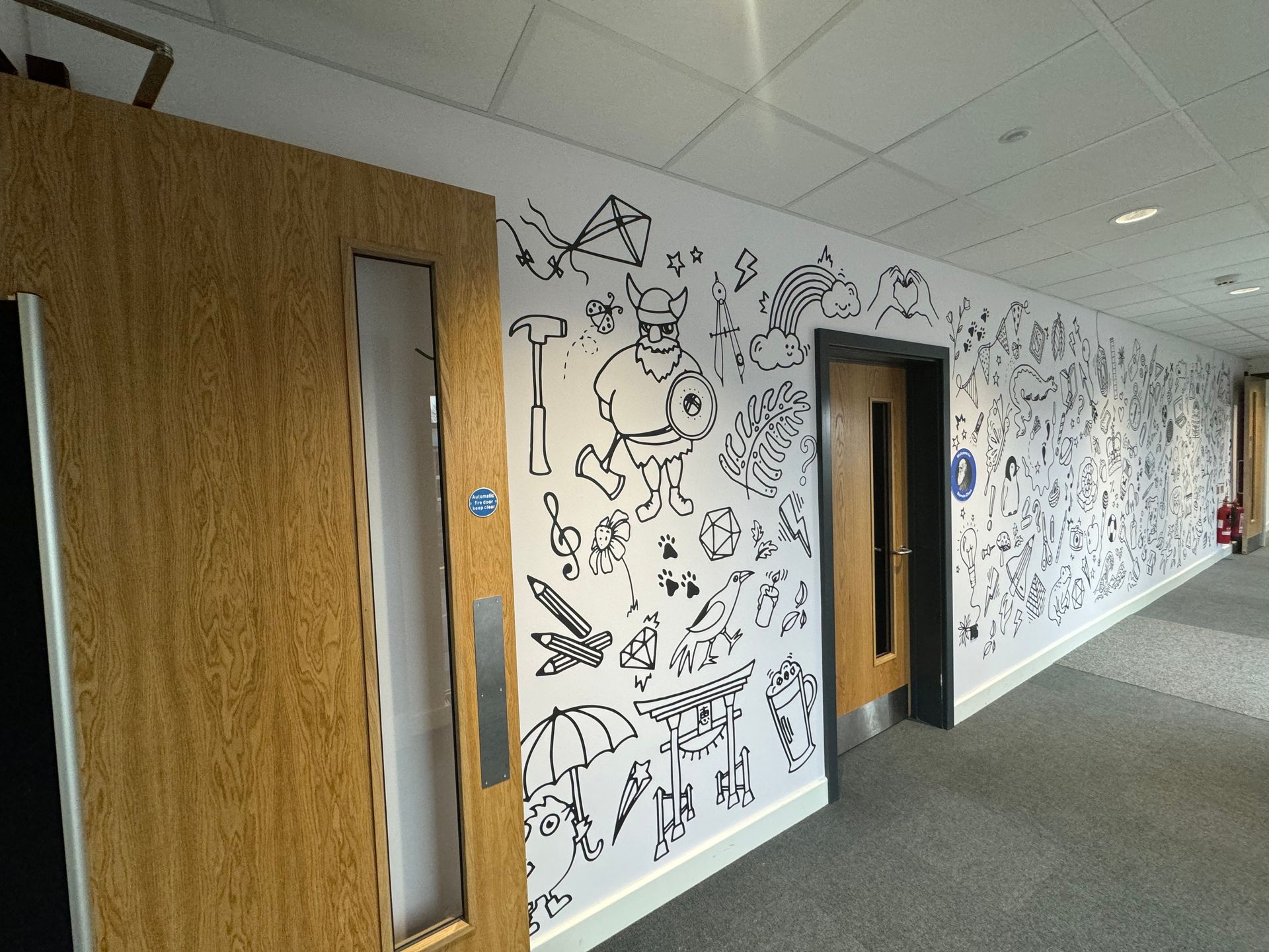 A hallway with a lot of drawings on the wall