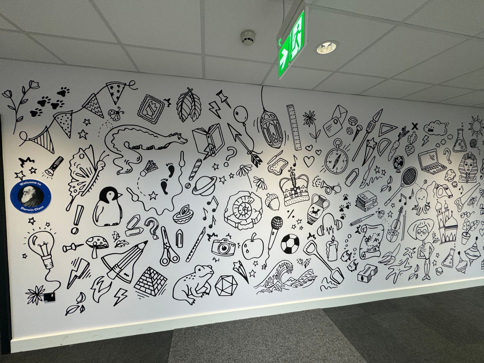A wall with a lot of black and white drawings on it