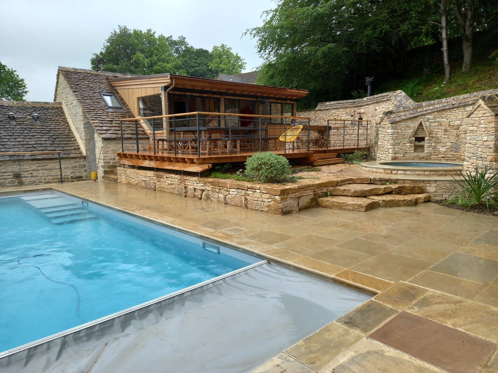 There is a swimming pool in the backyard of a house.