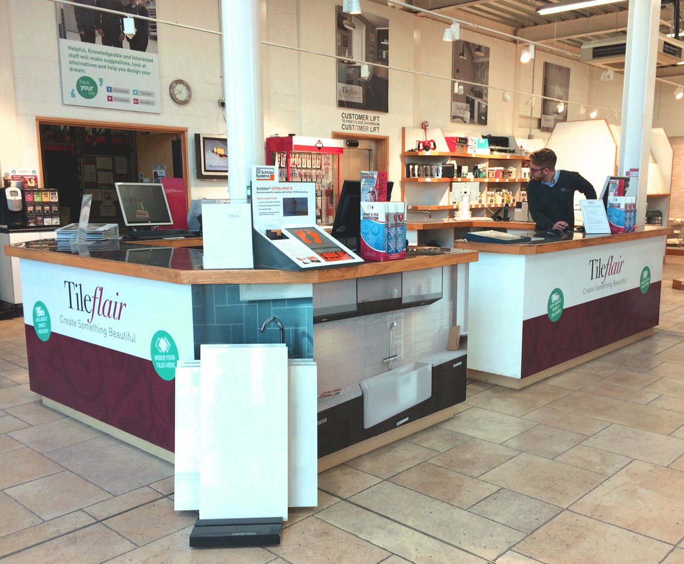 A man sits at a counter in a store that says ' yik flair ' on it