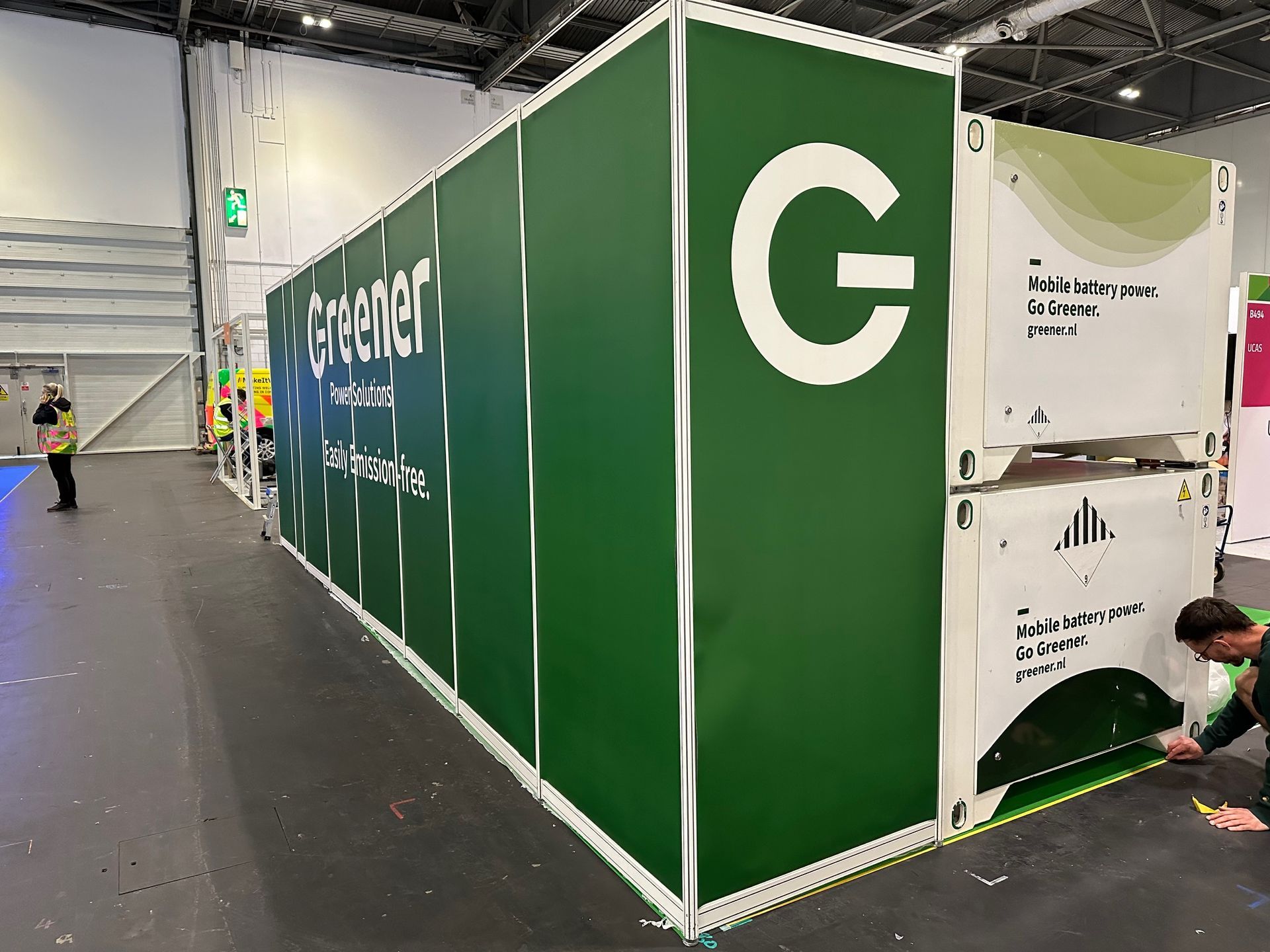 N3 Display Graphics | A man is measuring a green container with a white letter g on it.