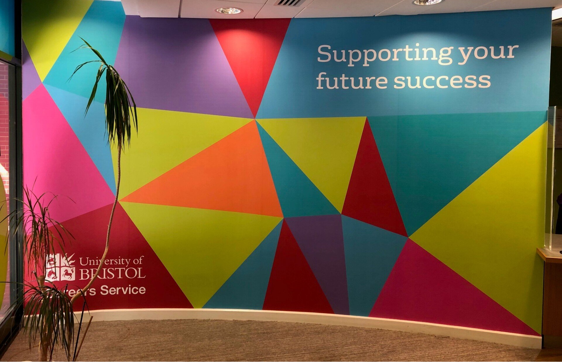 A colorful wall that says supporting your future success