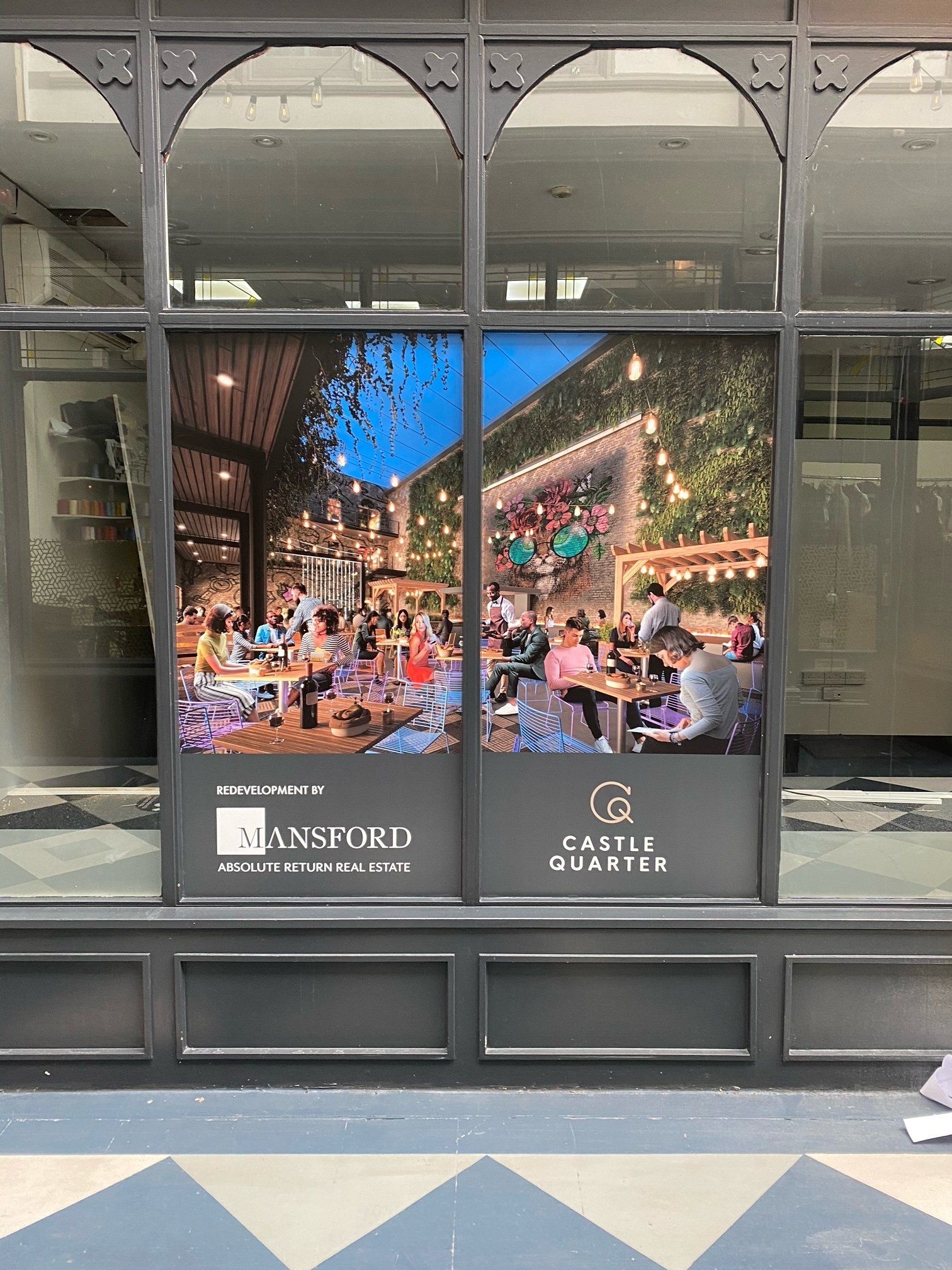 A window with a picture of people sitting at tables in it.