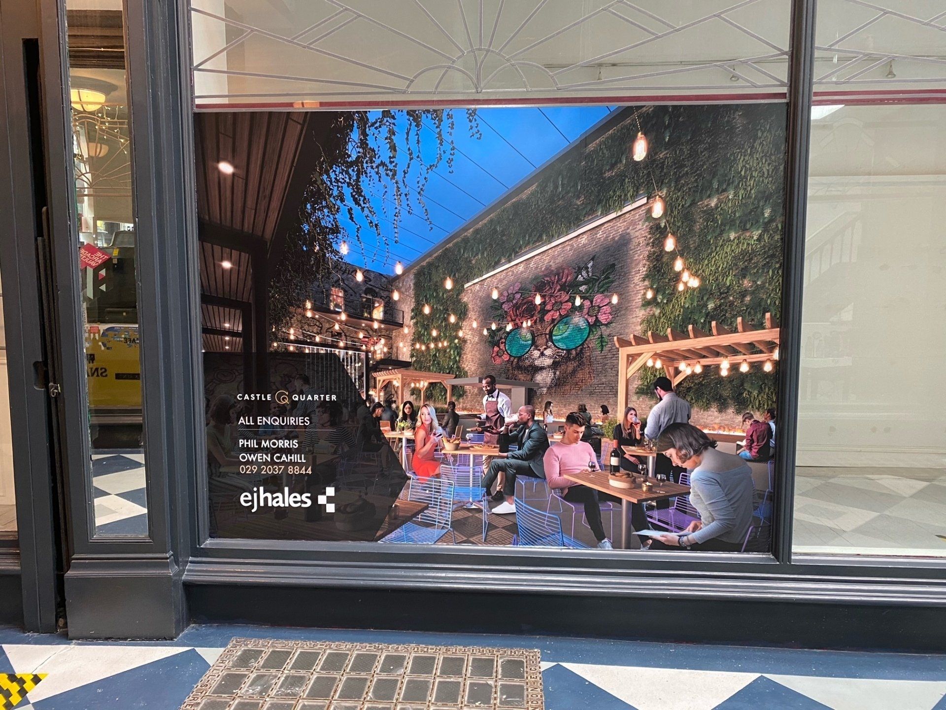 A window with a picture of people sitting at tables in a restaurant.
