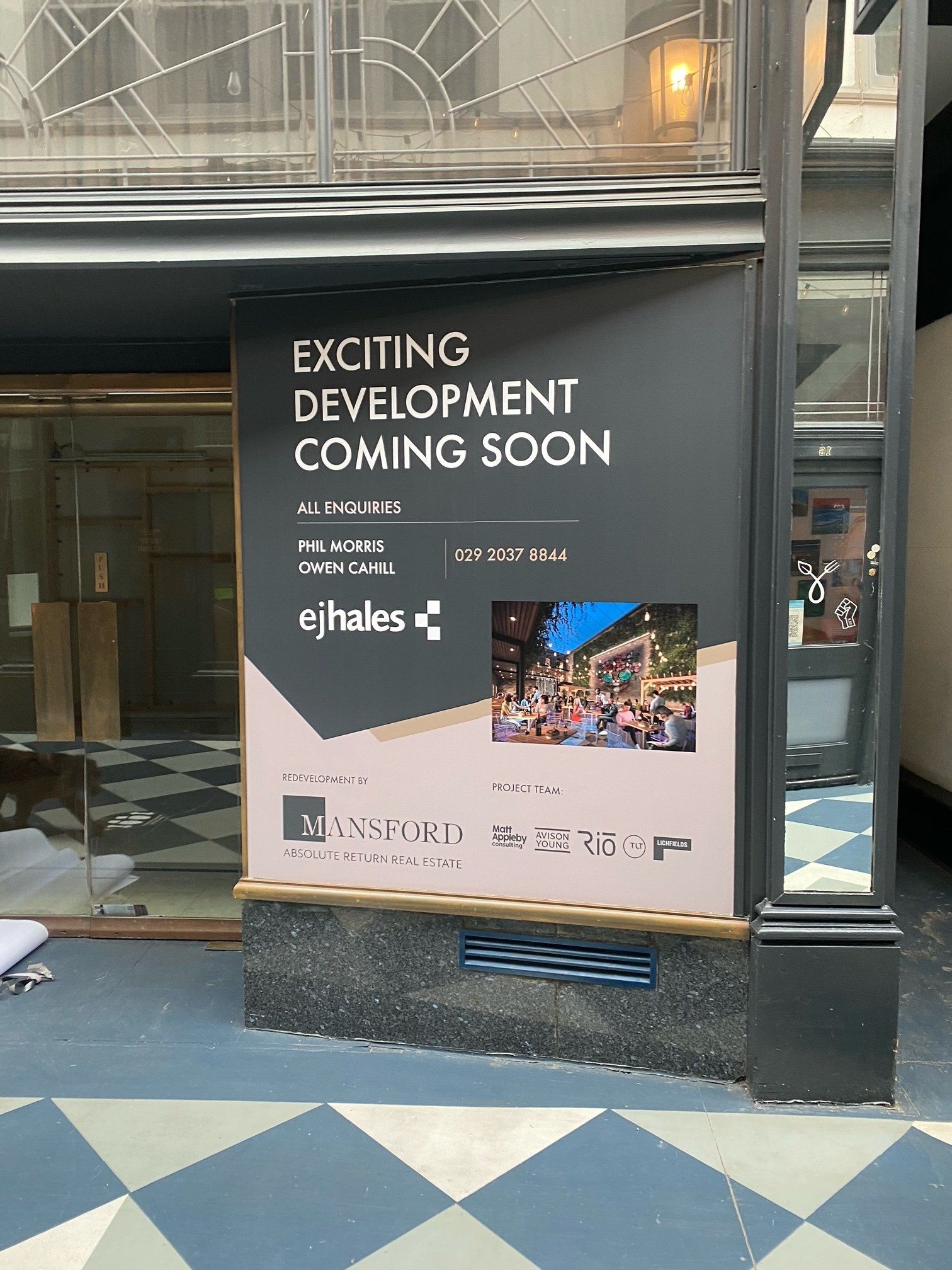 A sign on the side of a building that says exciting development coming soon.