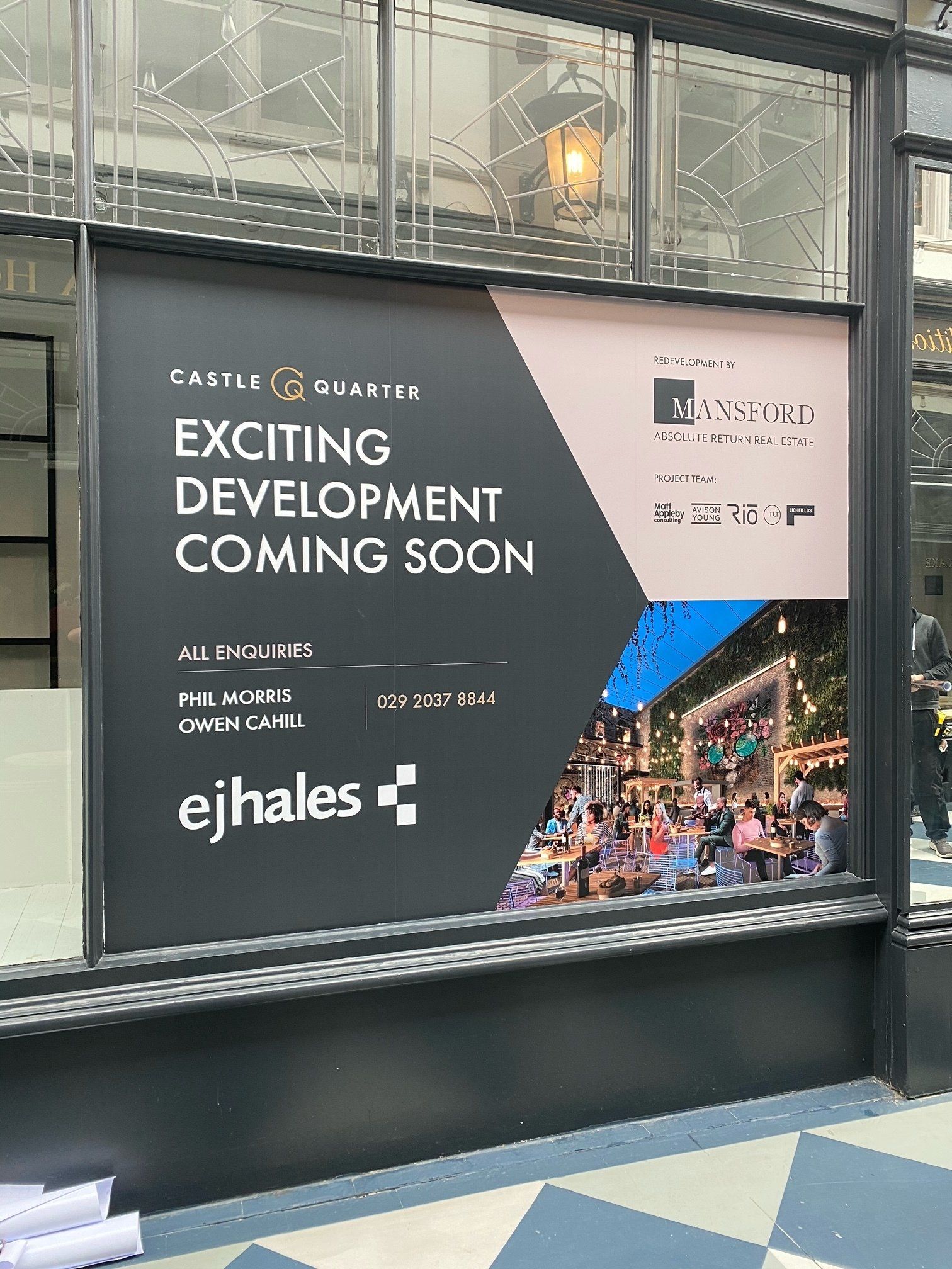 A large sign in a window that says exciting development coming soon.