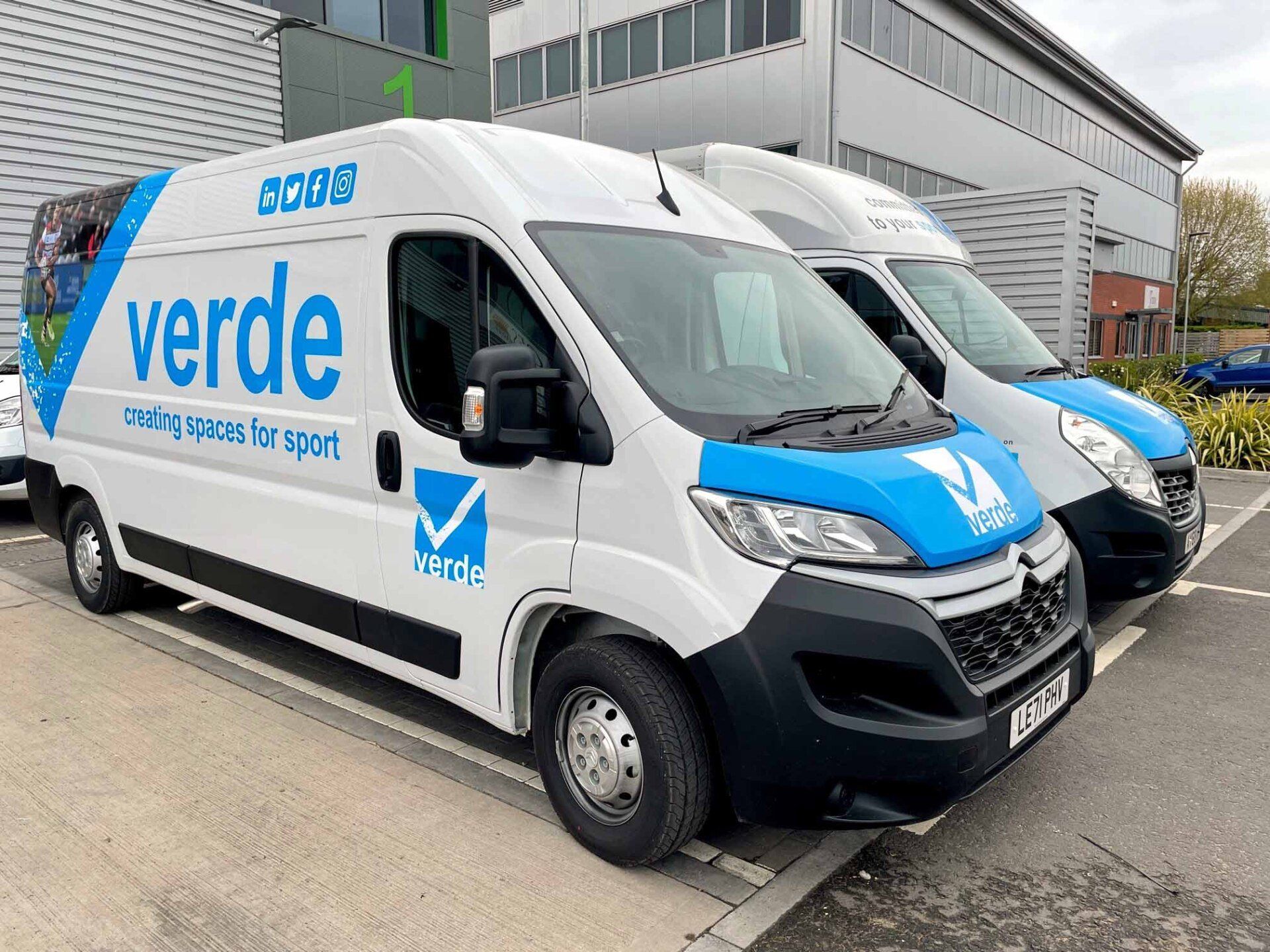 Two vans are parked next to each other in a parking lot.
