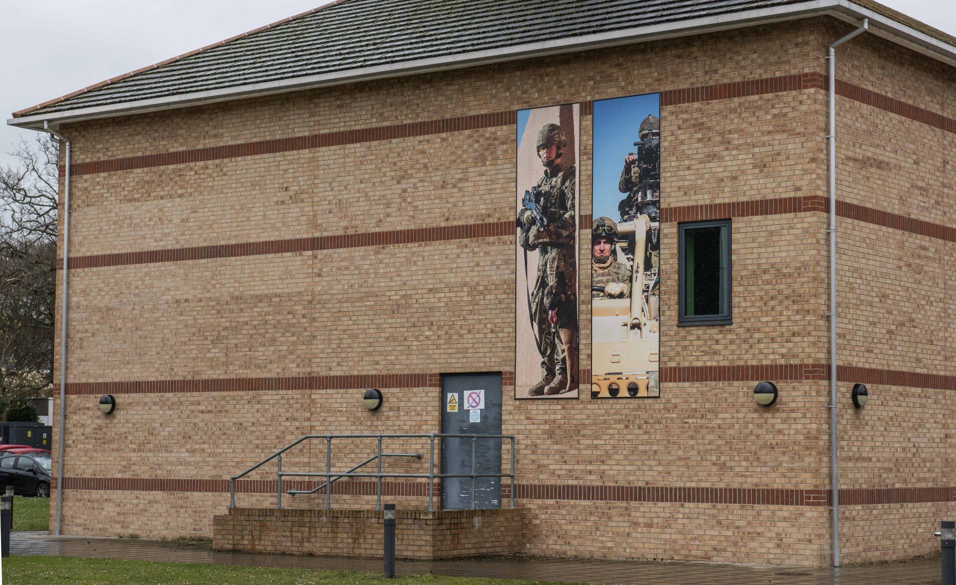 A brick building with two pictures of soldiers on the side