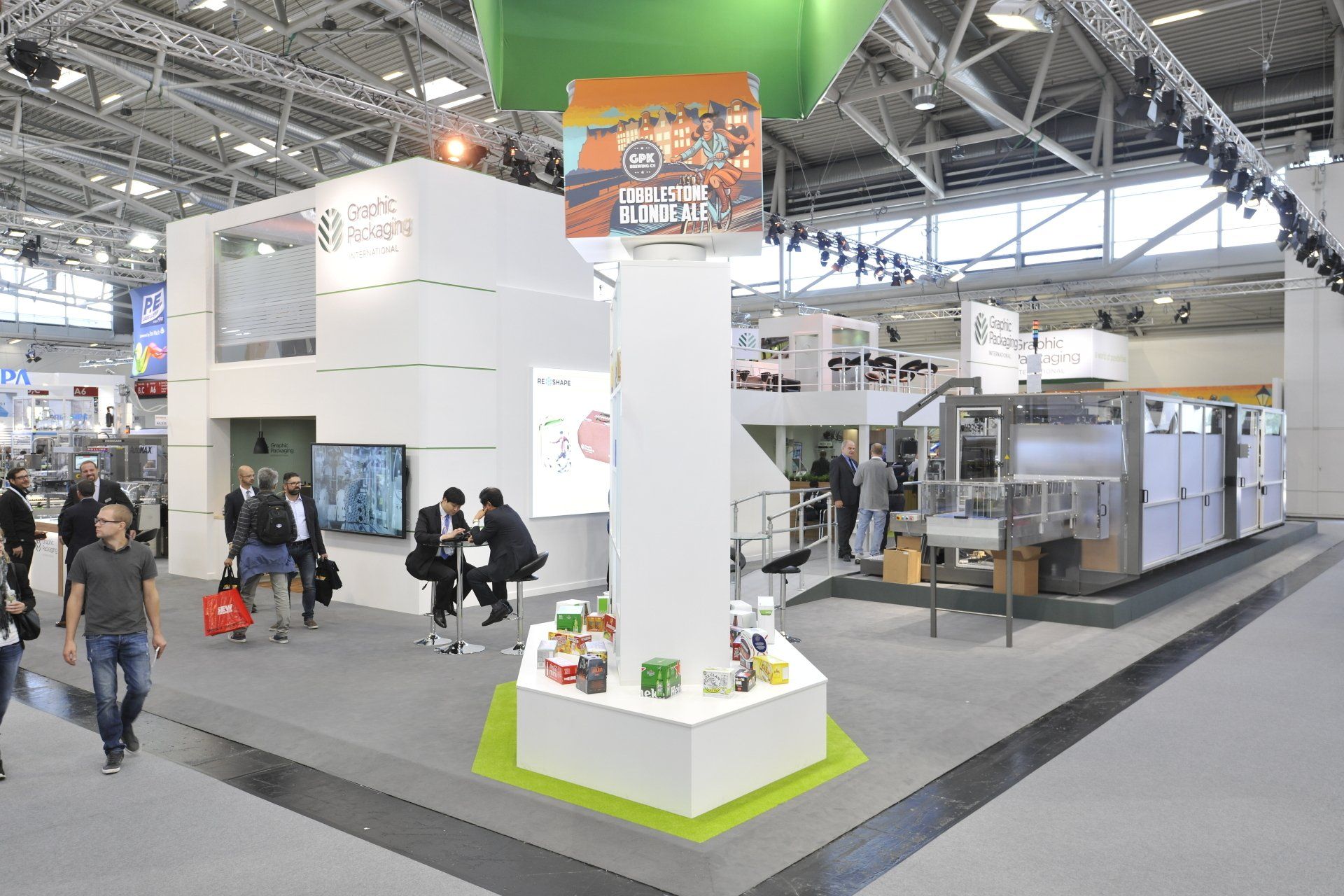 A group of people are walking around a large room with a display of products.