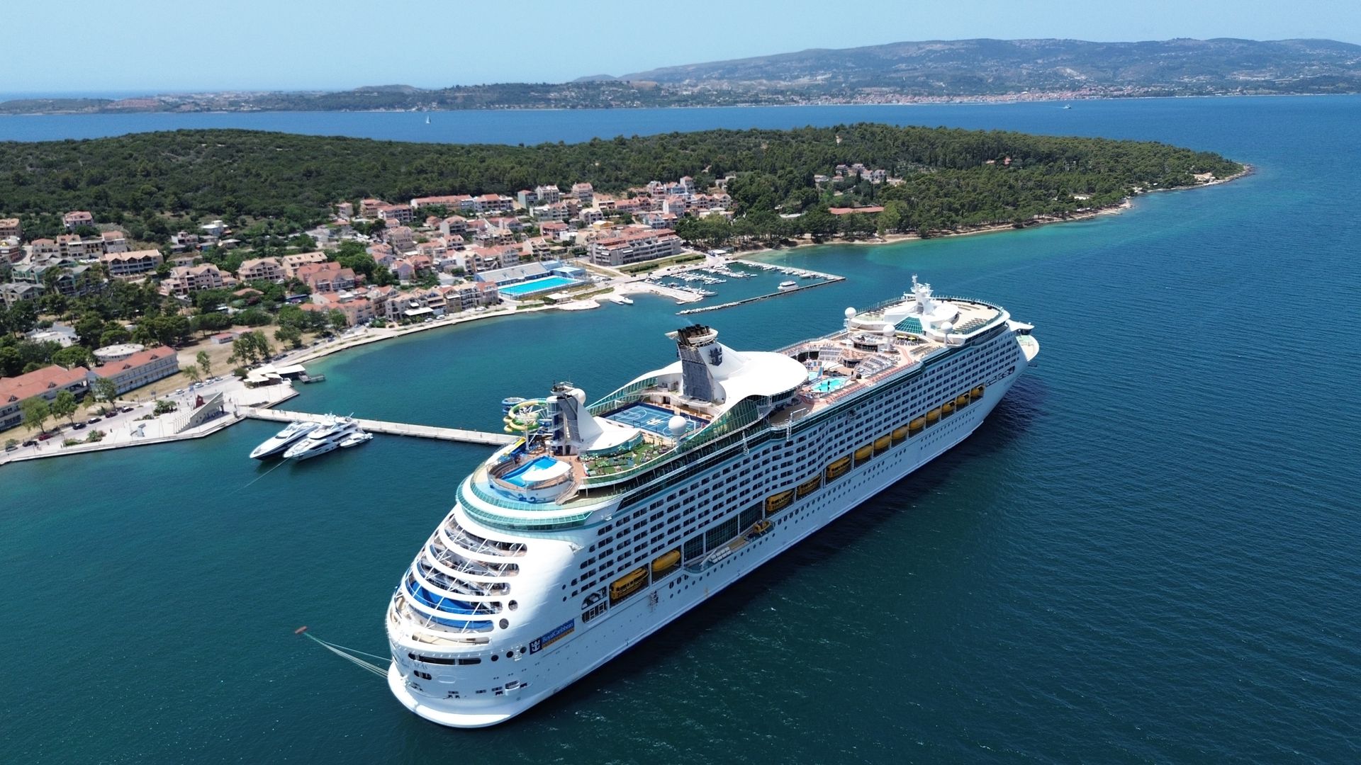 Cruise ship docked near a coastal town