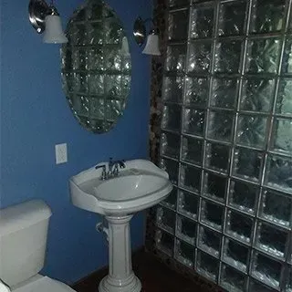A bathroom with a toilet , sink and mirrors.