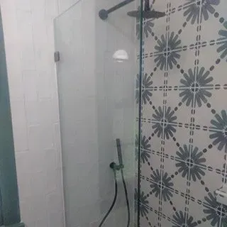 A bathroom with a shower stall and a shower head.