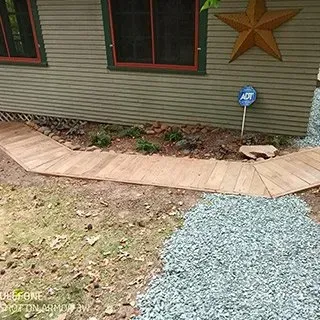 A wooden walkway leading to a house with a star on the side.