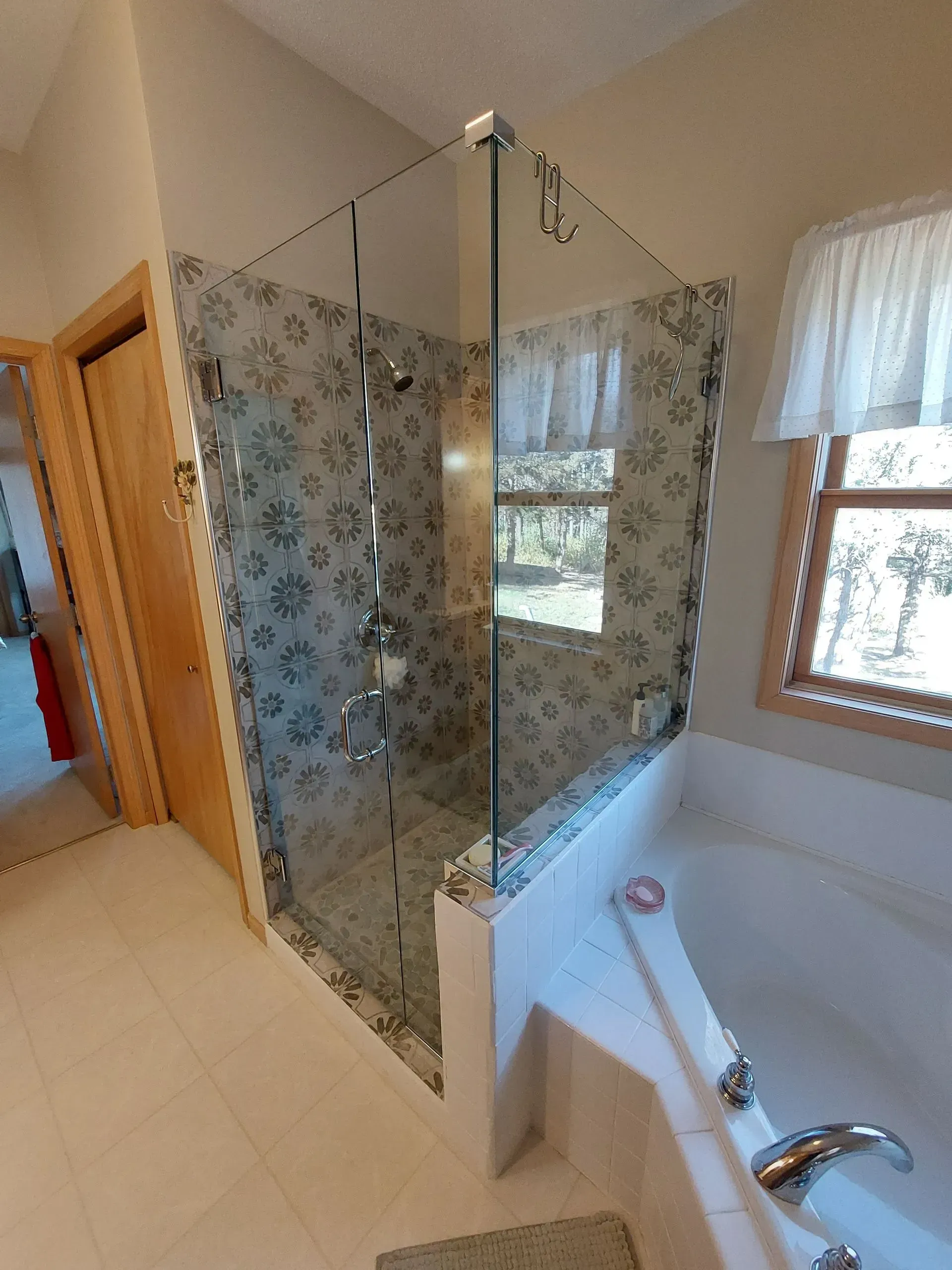 A bathroom with a tub and a shower with a glass door.