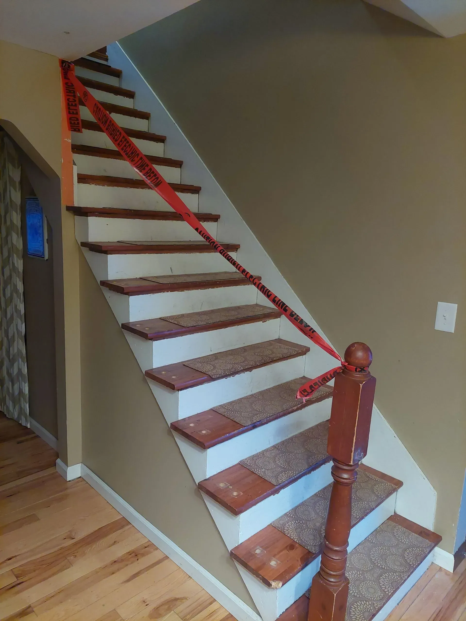 A wooden staircase with a red railing in a house