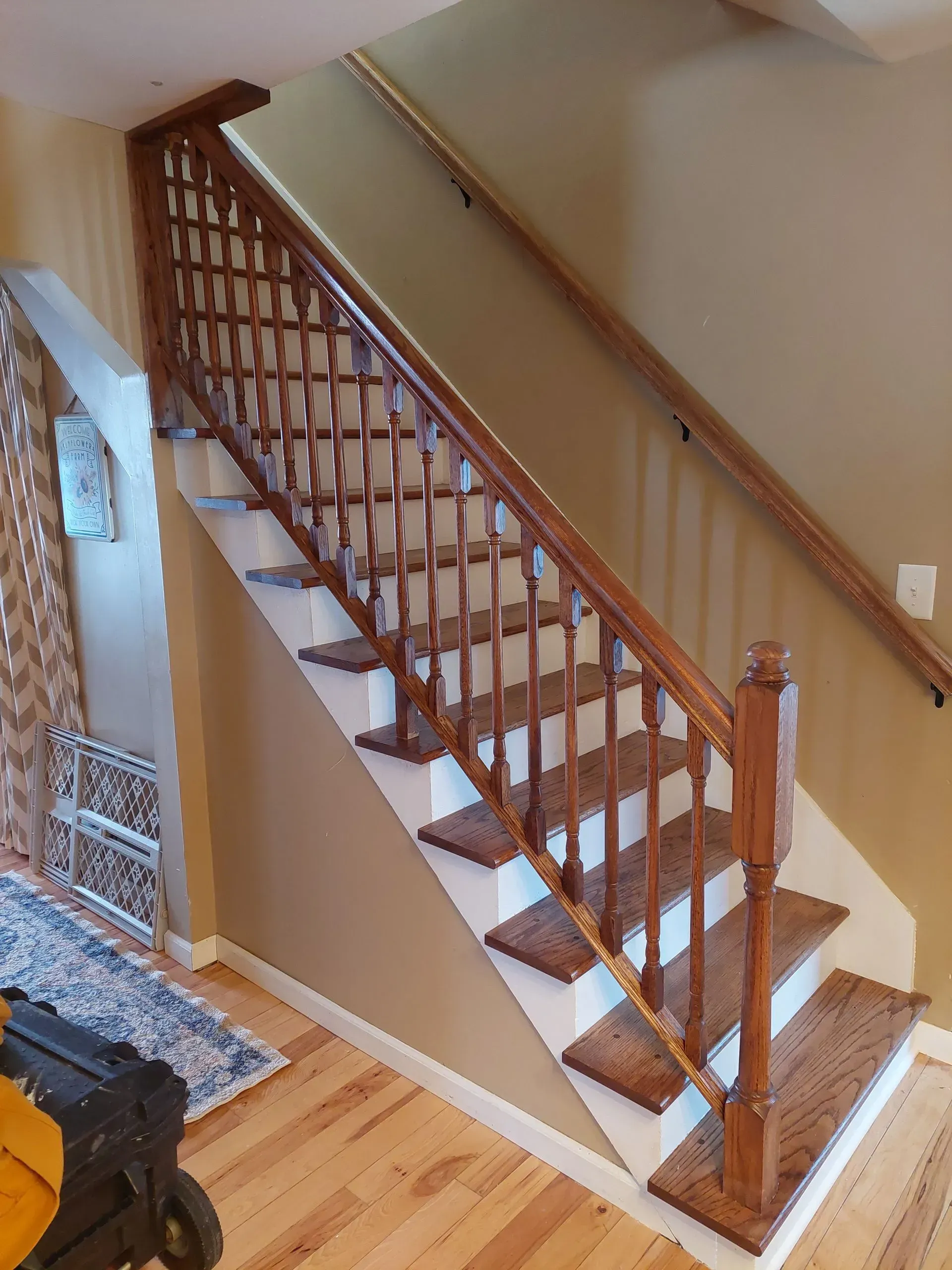 A wooden staircase with white steps and a wooden railing