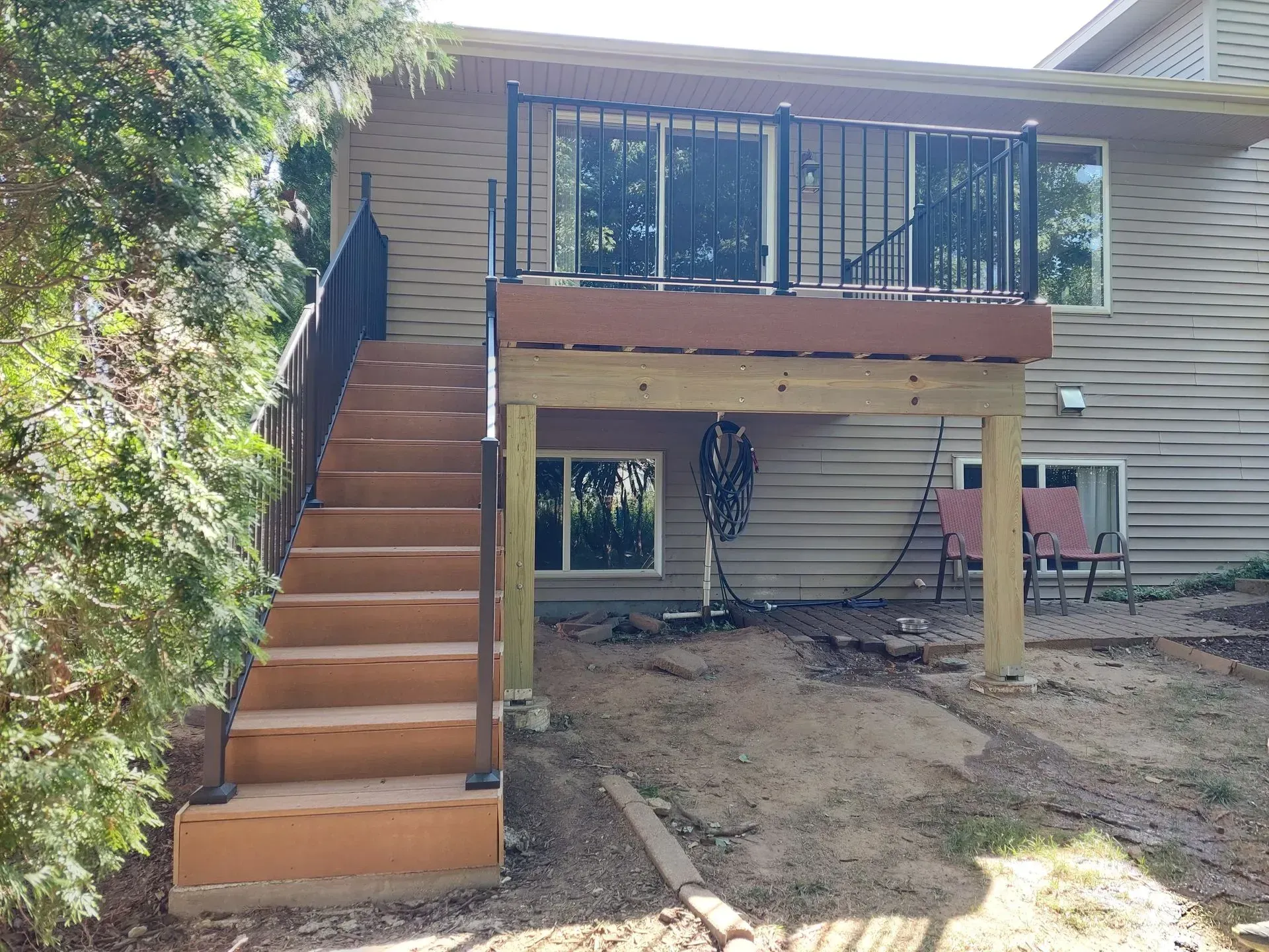 A house with a wooden deck and stairs leading up to it.