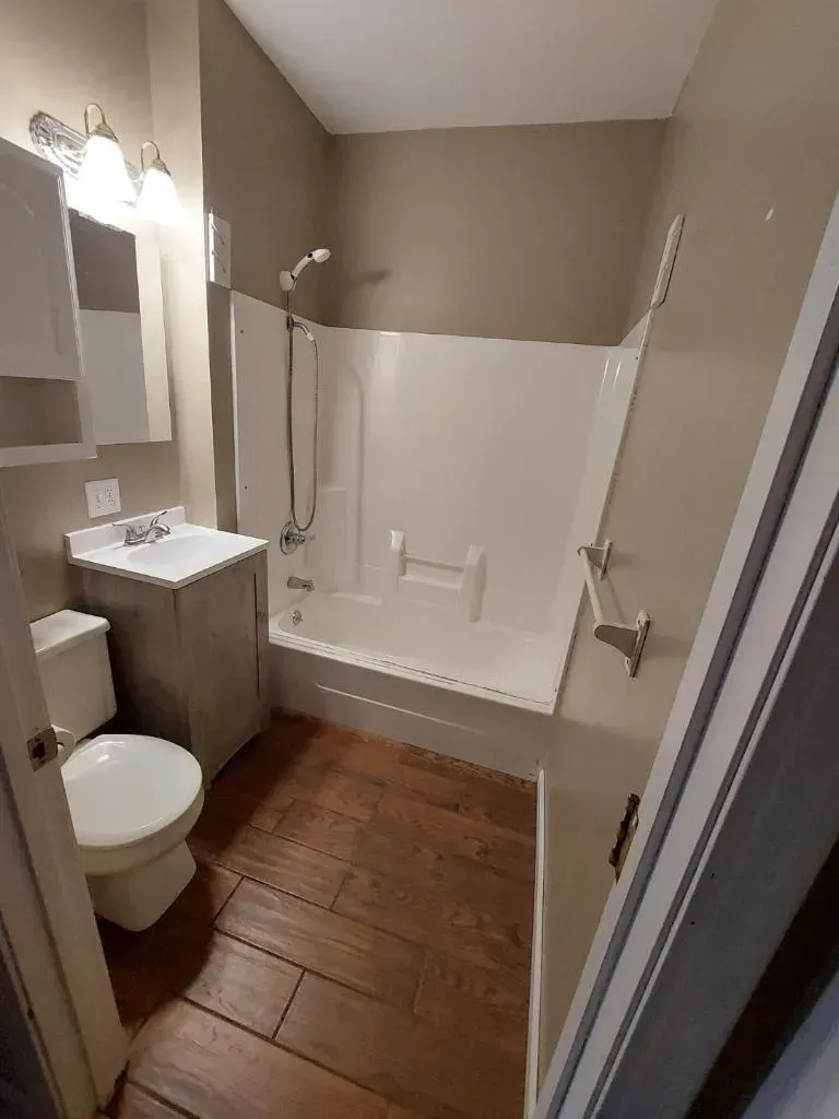 A bathroom with a toilet , sink , bathtub and shower.