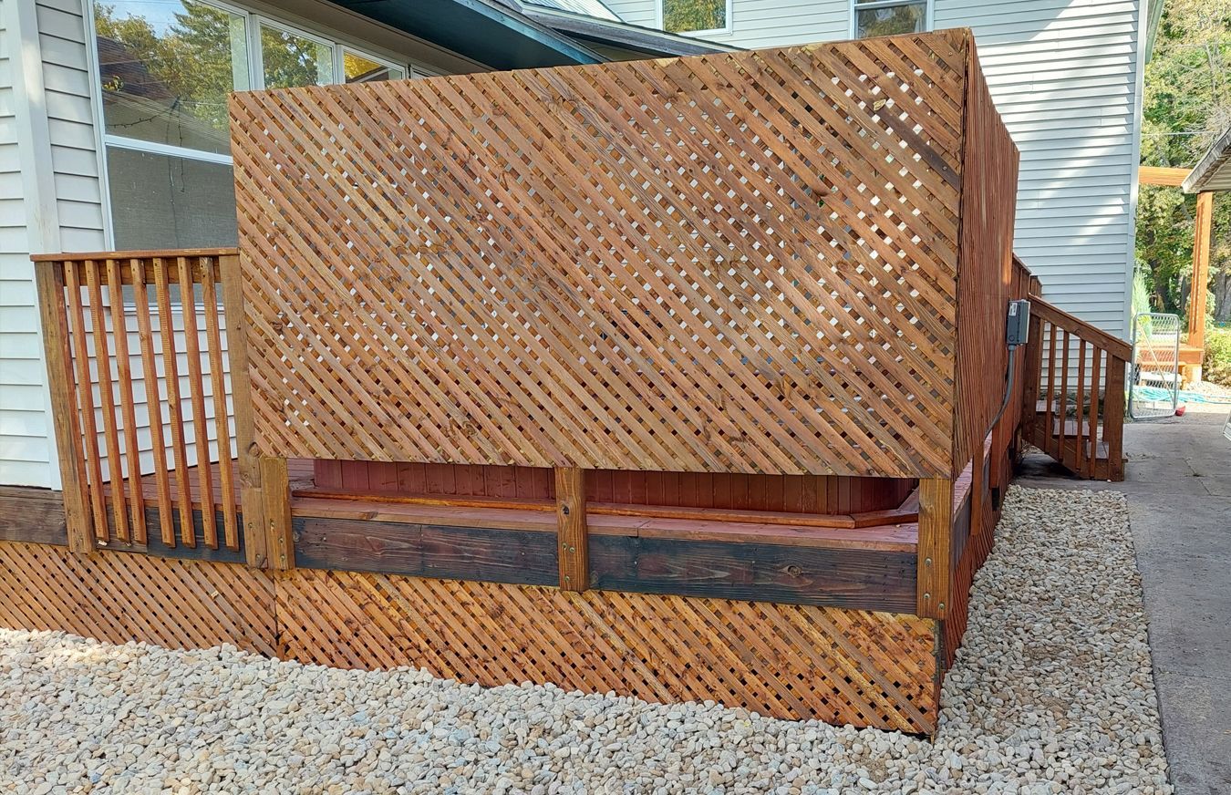 A wooden deck with a lattice fence surrounding it.