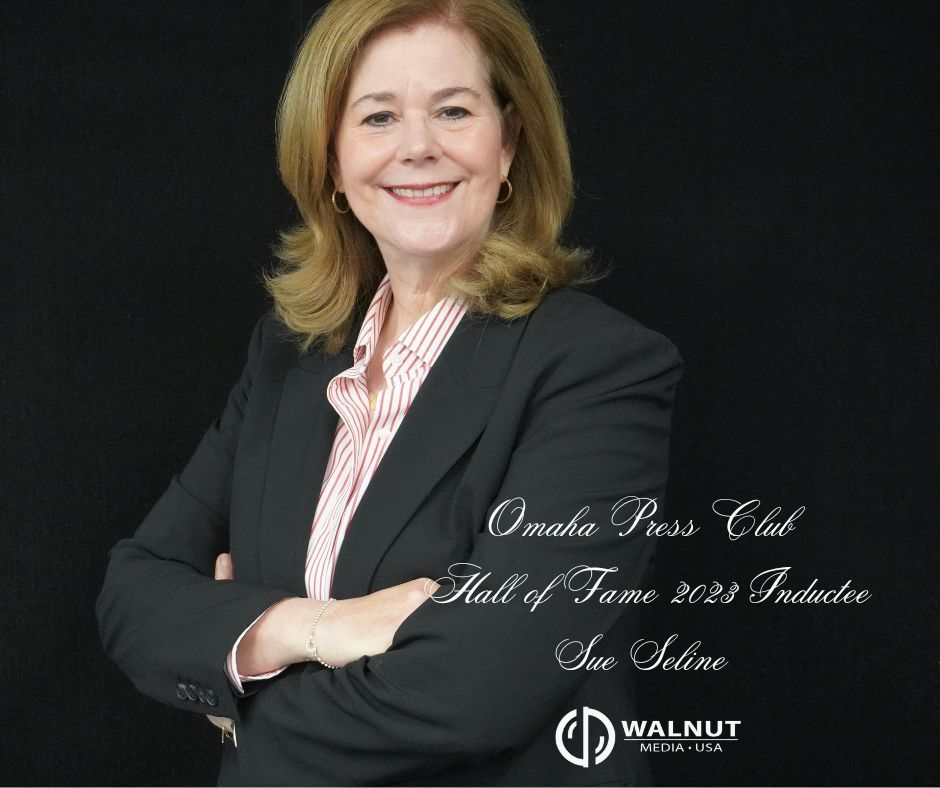 Headshot of Sue Seline, 2023 Omaha Press Club Hall of Fame inductee, wearing a black blazer against a black background.