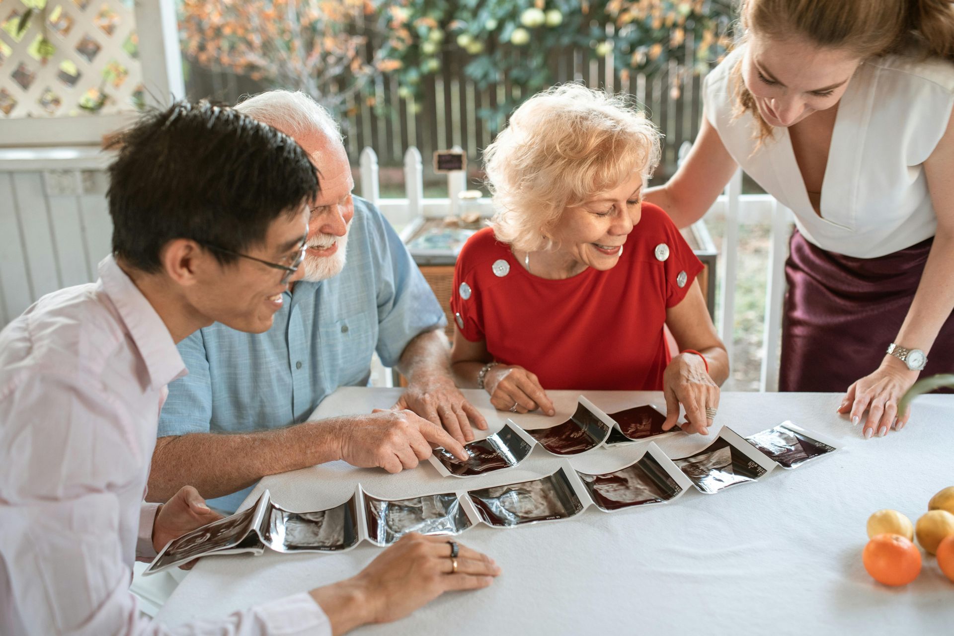 A woman is sitting at a table holding a blister pack of pills.