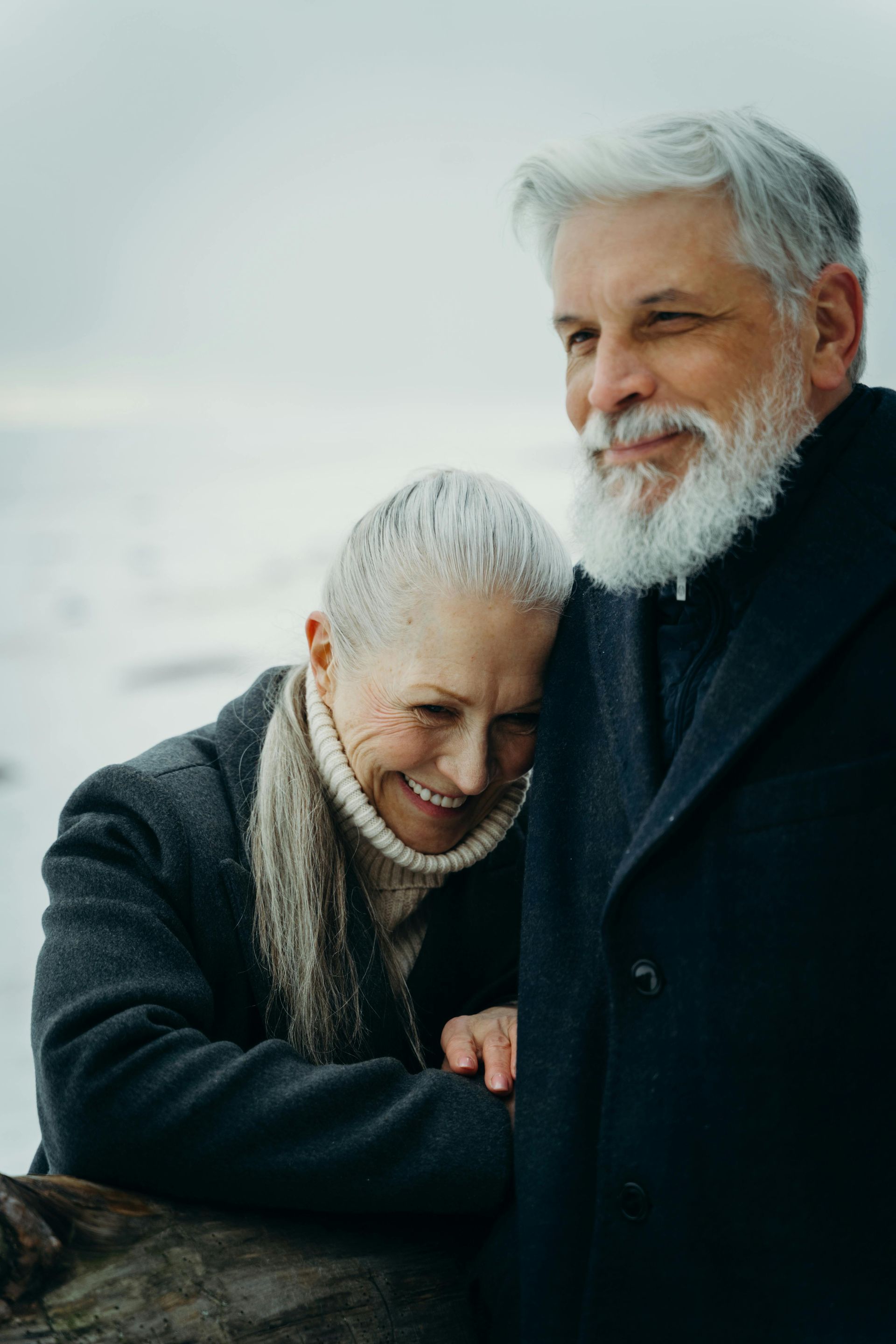 A man and a woman are hugging each other on a beach.