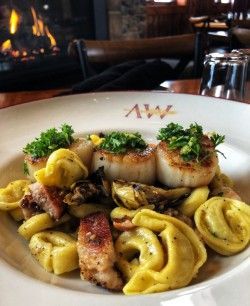 A close up of a plate of food on a table with a fireplace in the background.