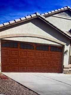A large brown garage door is in front of a house.