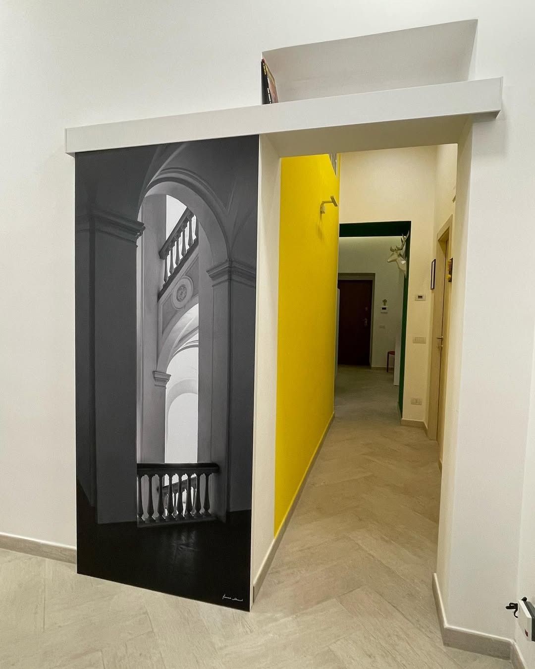 Un corridoio con l'immagine di un edificio sul muro