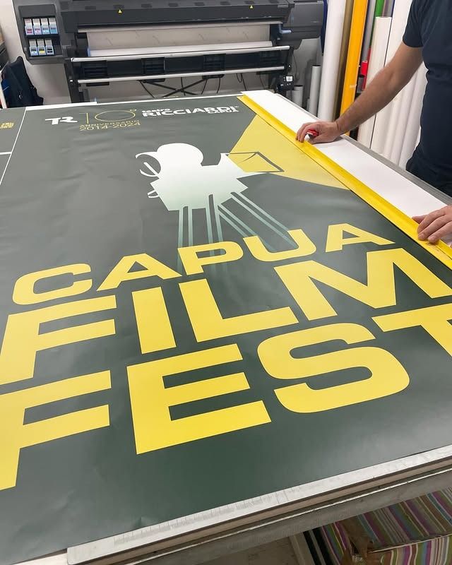 Un uomo sta lavorando a un grande manifesto per il Papua Film Fest