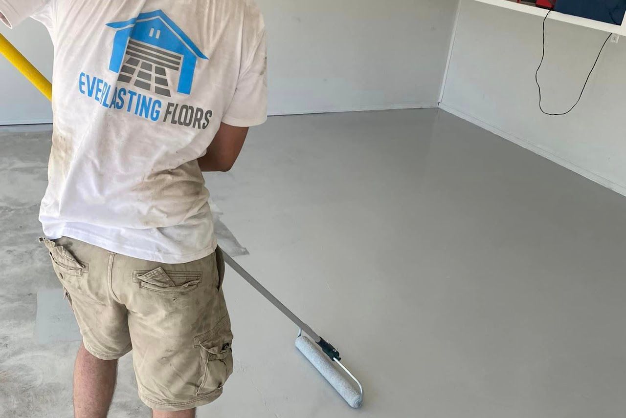a man wearing a shirt that says everlasting floors polishing the garage floor