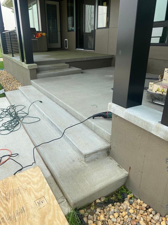 A concrete porch with stairs being built in front of a house.