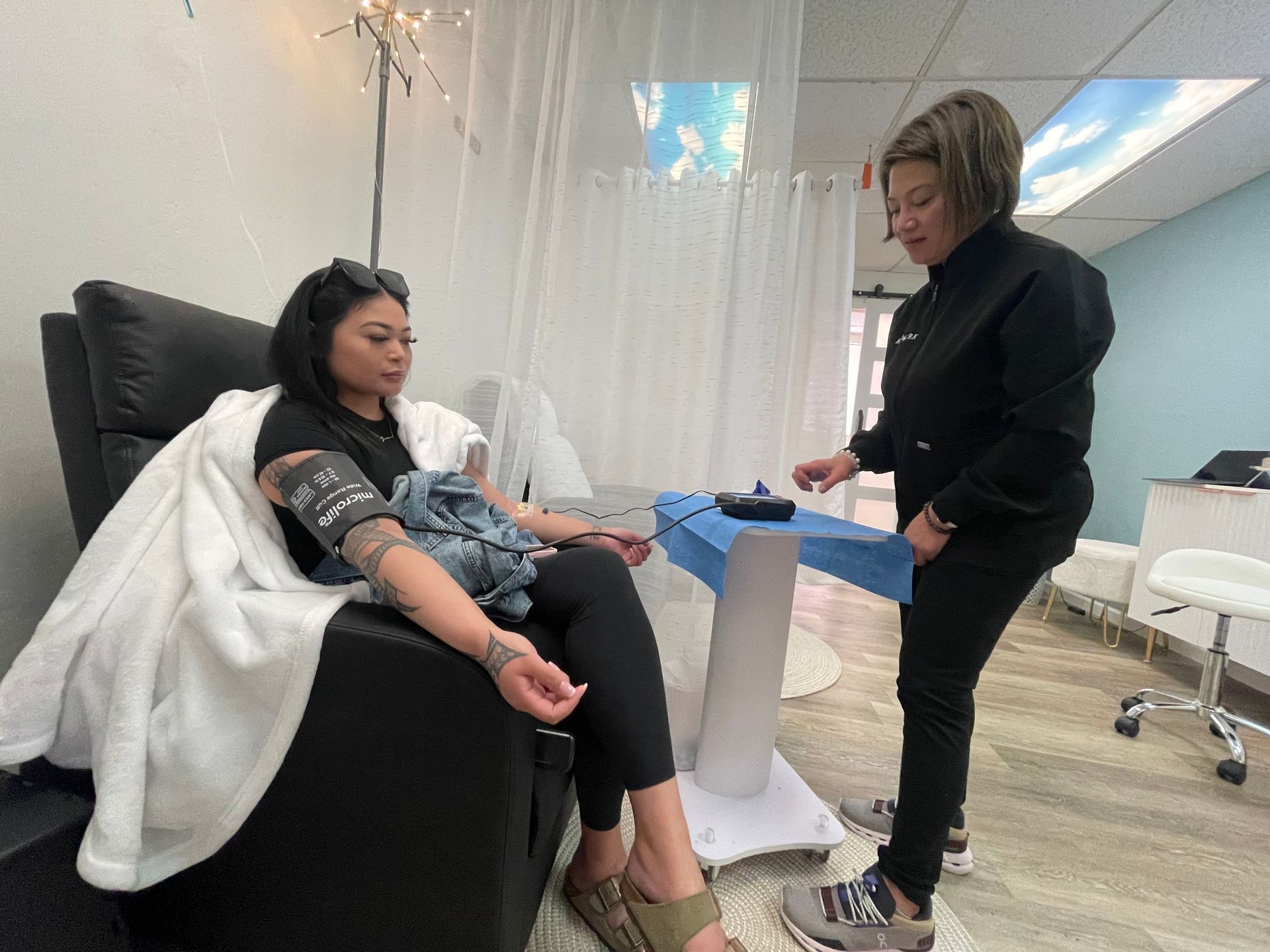 Person getting blood pressure checked by a medical professional in a well-lit medical setting.